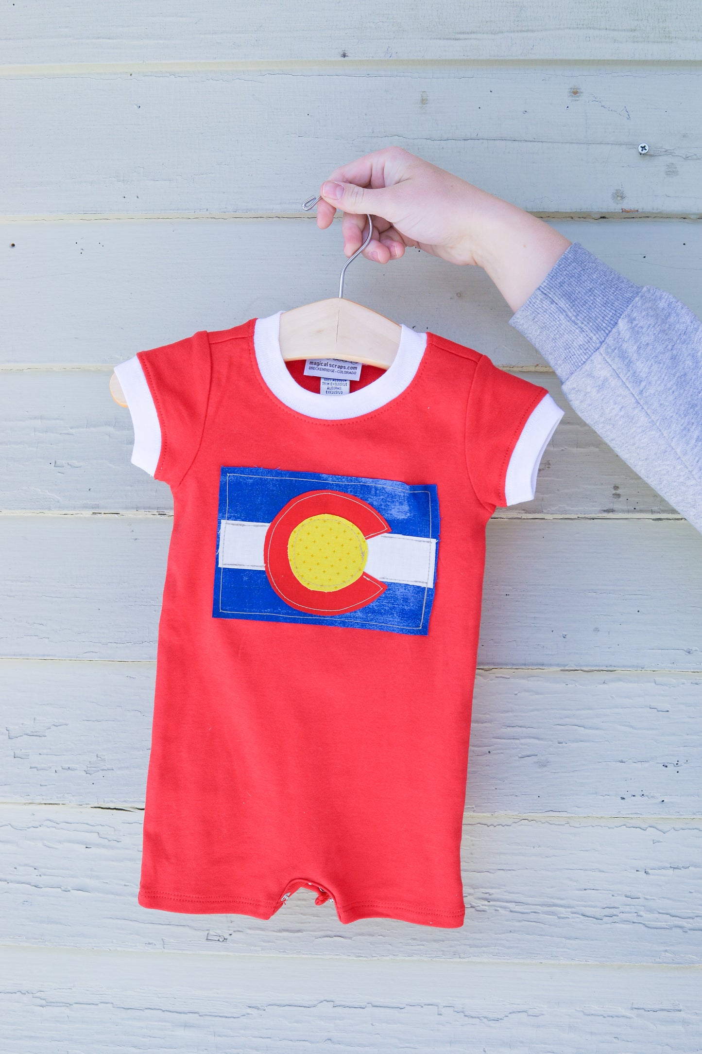 Colorado Flag sewed onto red baby romper